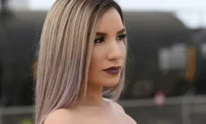 Kobieta z blond włosami, które wyglądają jak po zabiegu nanoplastia w domu. Makijaż podkreśla jej urodę.