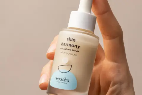 Dłoń trzyma serum Resibo Skin Harmony. Zastanawiasz się, alantoina co to? To składnik nawilżający i łagodzący.