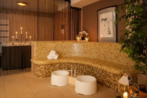 Relaks w spa: mozaikowa ławka, świece, wanna i rośliny tworzą atmosferę spokoju.