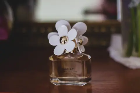 Flakonik perfum Daisy Marc Jacobs z białymi kwiatkami. Czy perfumy mają datę ważności? Ten zapach wciąż zachwyca.