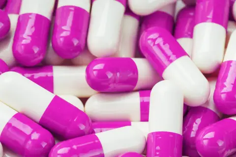 Mnóstwo białych i fioletowych kapsułek. Kiedy brac probiotyk? Zawsze warto skonsultować się z lekarzem lub farmaceutą.
