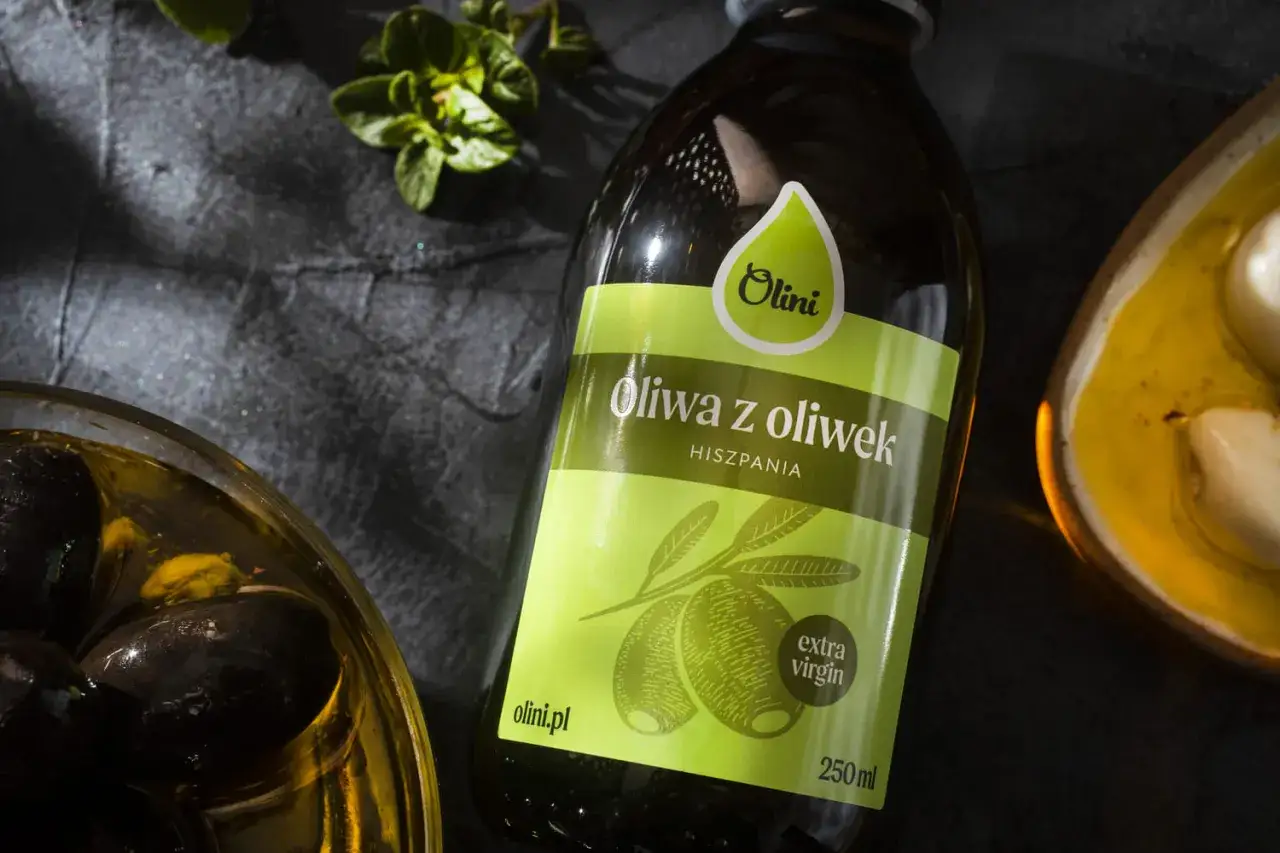 Oliwa z oliwek na twarz? Ta hiszpańska extra virgin Olini to sekret pięknej skóry. Obok czarne oliwki i czosnek.